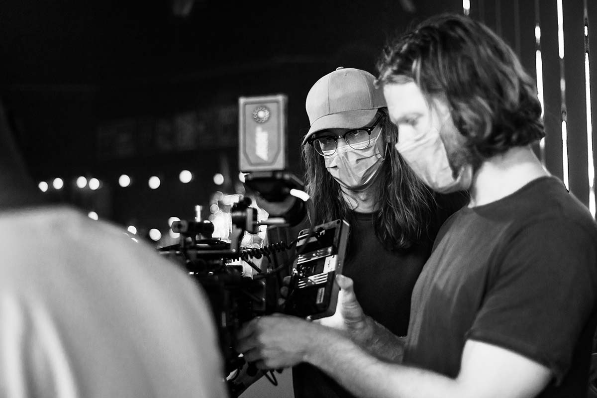 Crew stand behind a camera on the set of Scattered