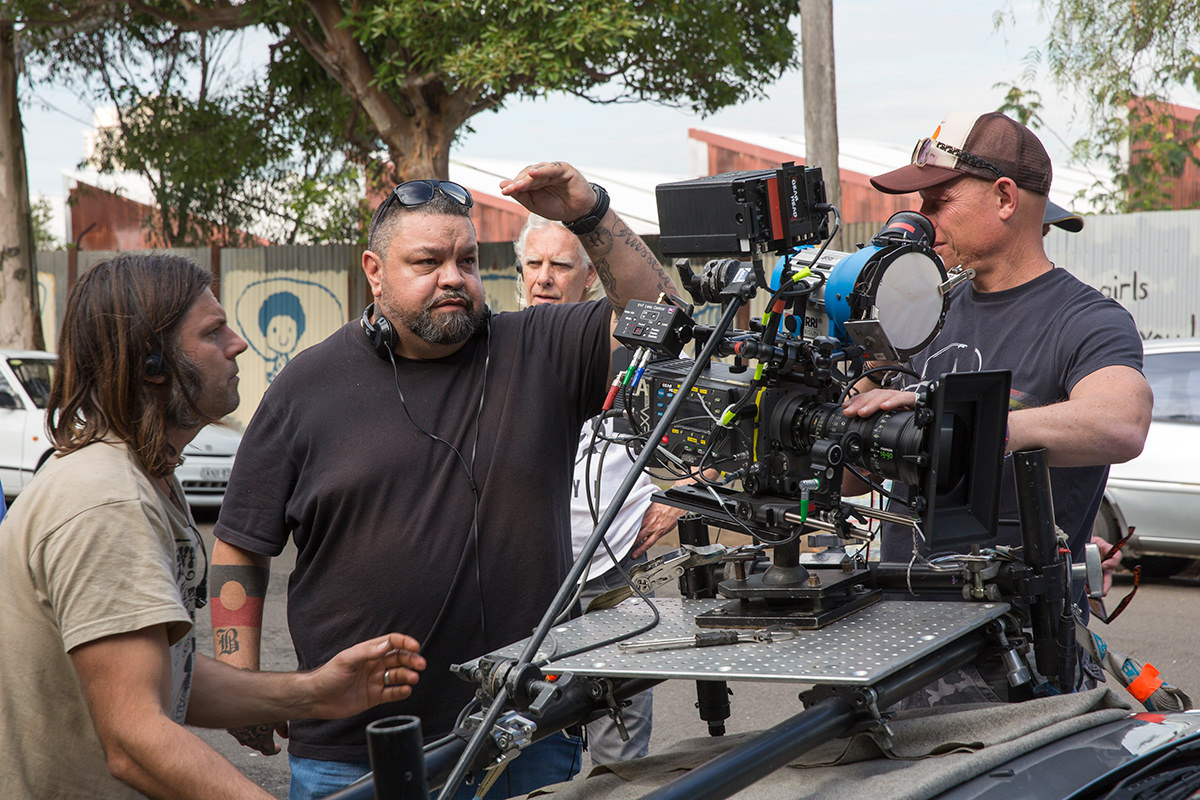 Adrian Russell Wills stands behind a camera on the set of Redfern Now.