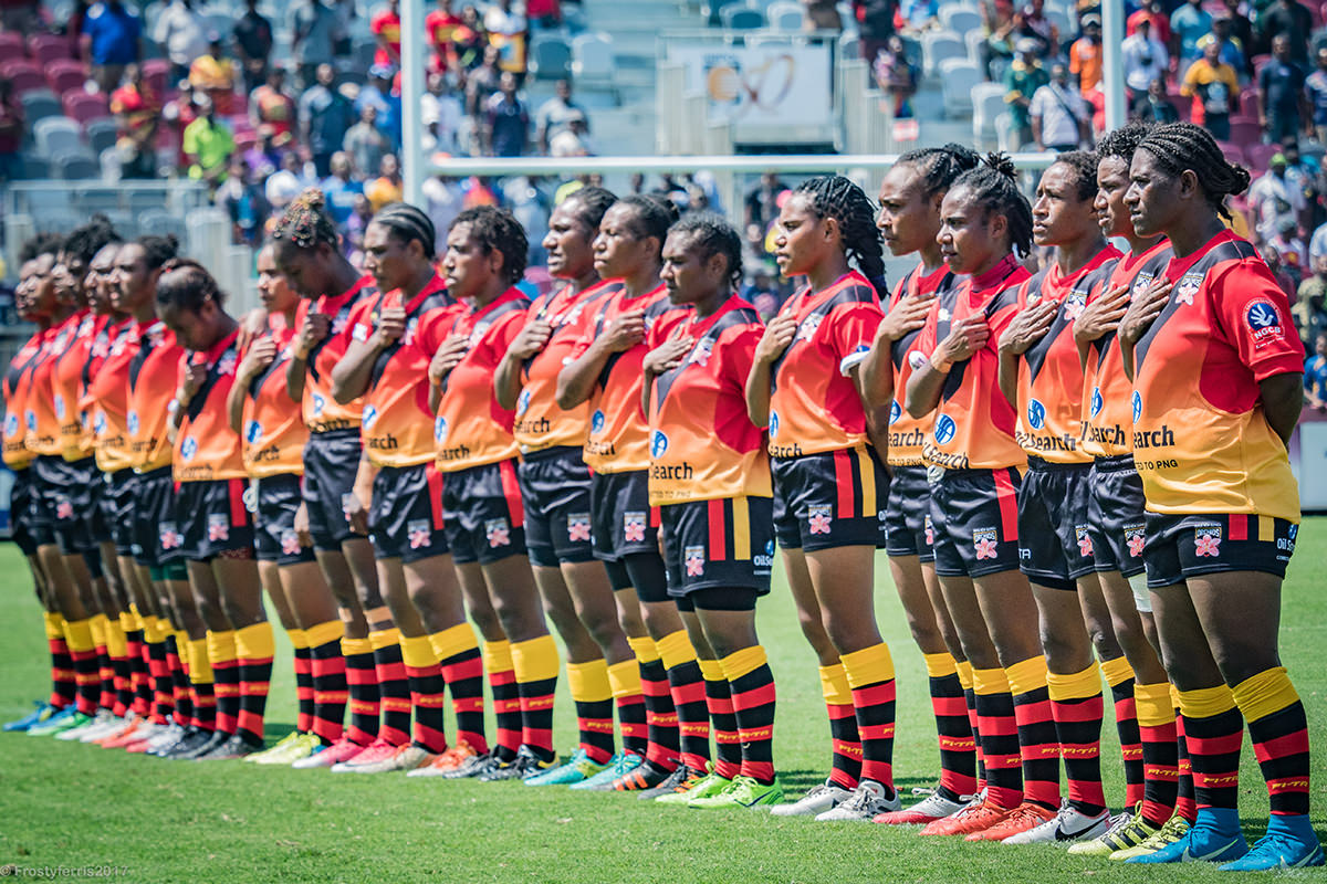 The PNG Orchids rugby team line up on the field before their game