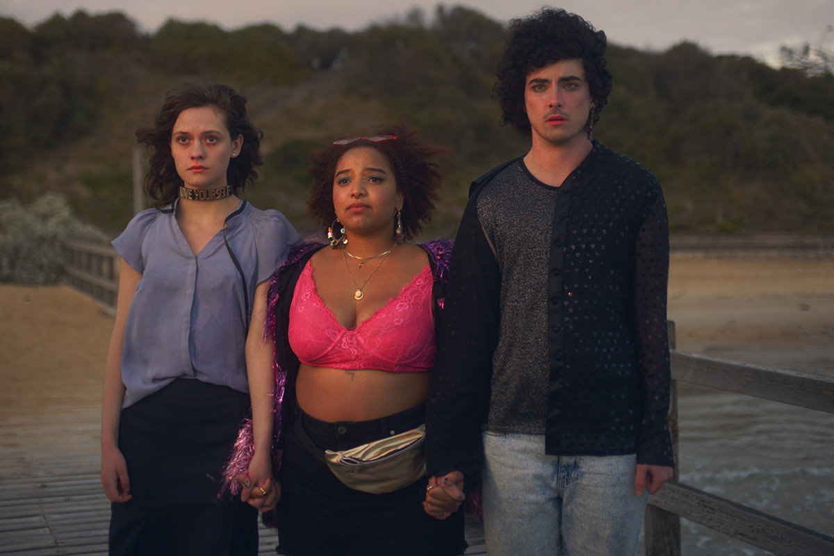 Still from TikTok series Scattered. Three people stand together on a pier, holding hands.