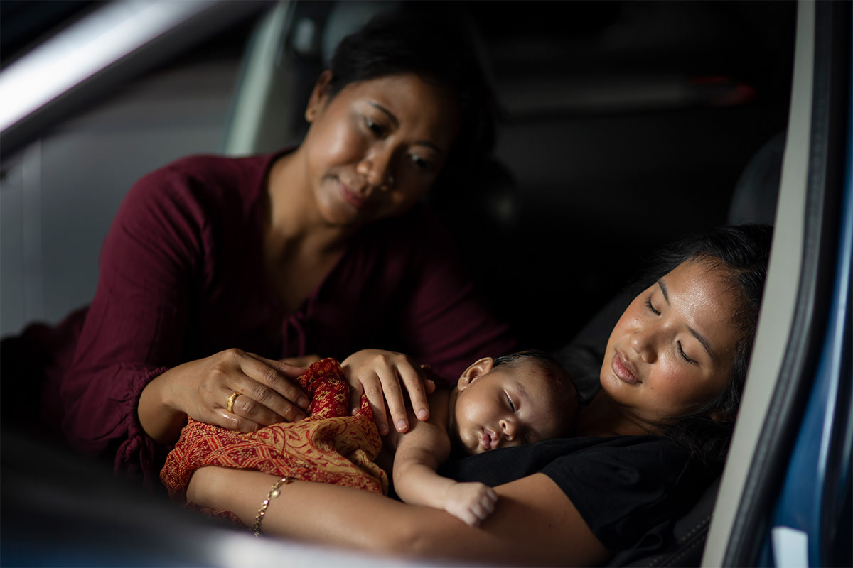 Still from Mother Tongue, two women hold a baby.