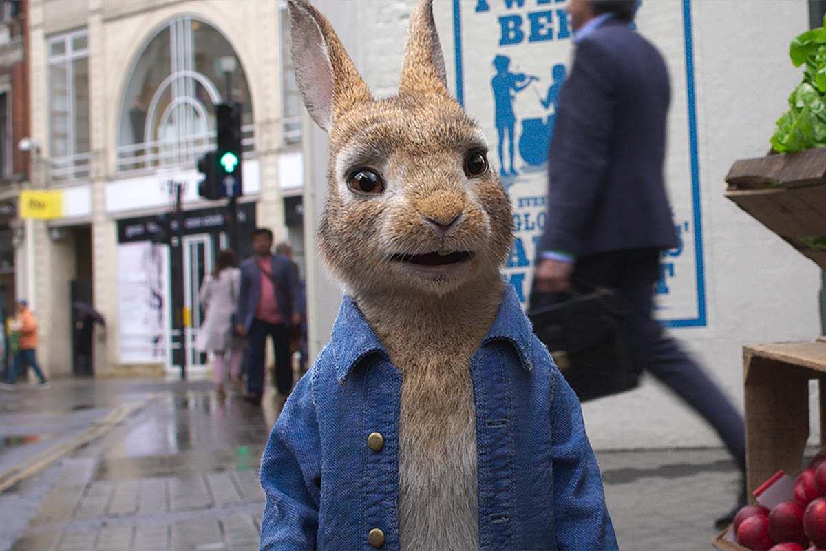 Peter Rabbit stands on a busy footpath in the city.