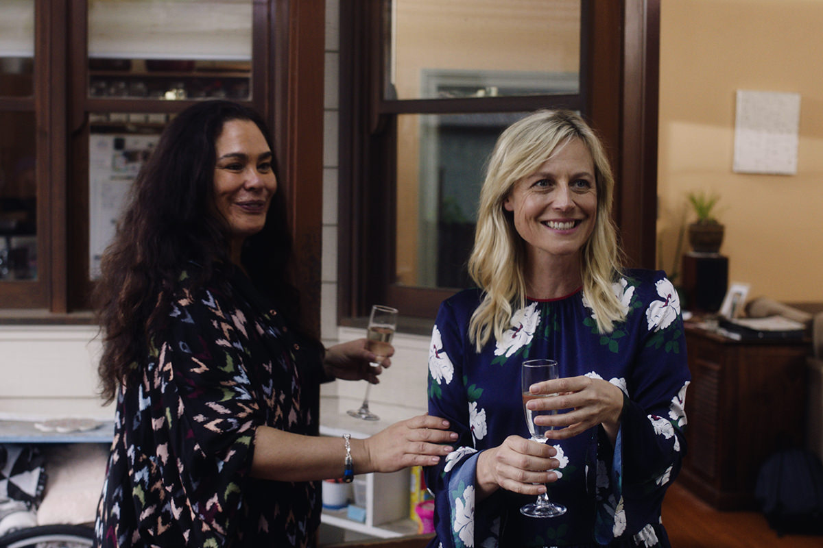 Two women holding glasses of champagne, smiling