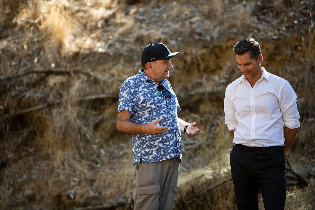 Robert Connolly and Eric Bana stand with one another talking on the set of The Dry