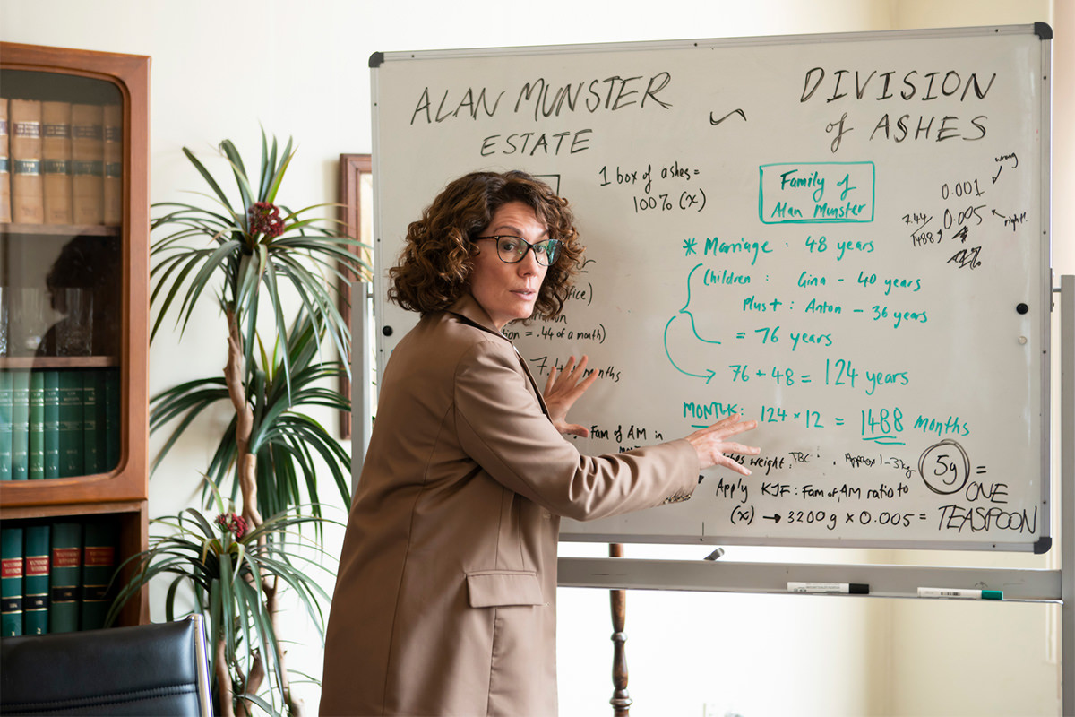 Production still from Fisk, Kitty Flanagan stands in front of a whiteboard.