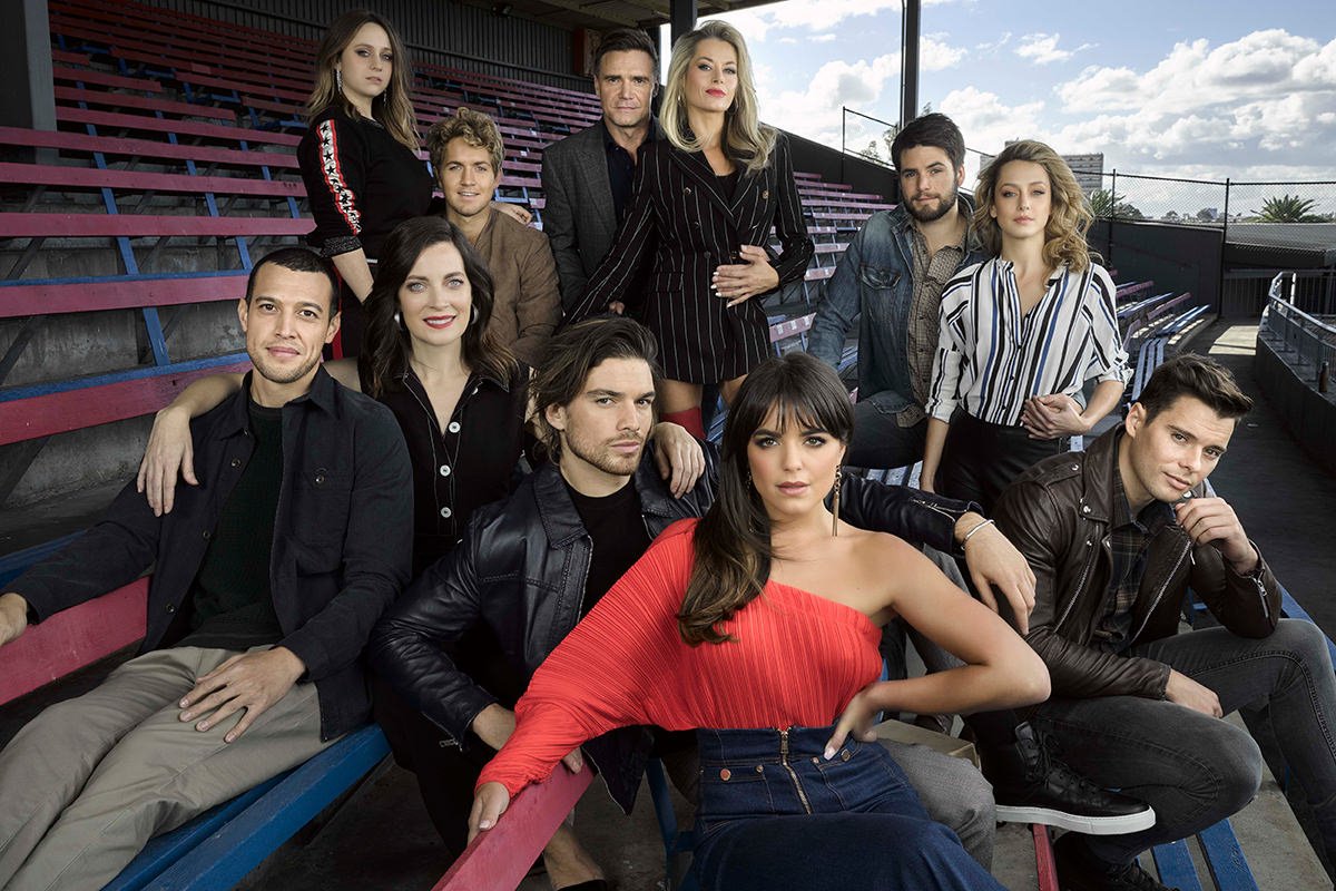 The cast of Playing For Keeps gather in the stand of a sport stadium