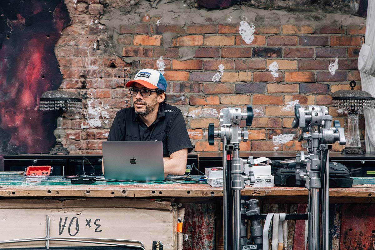 Mark Broadbent ACS sits with laptop on the set of Incarceration Nation