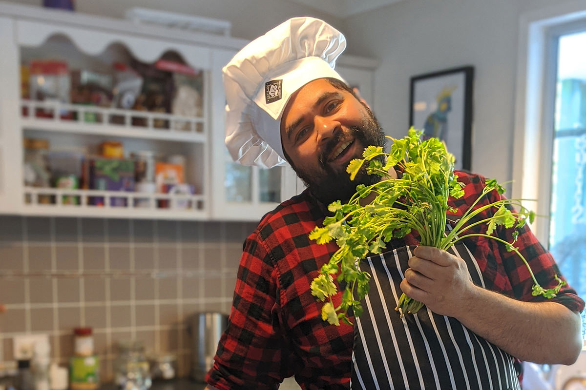 Bjorn Stewart posing in a kitchen with a bunch of coriander
