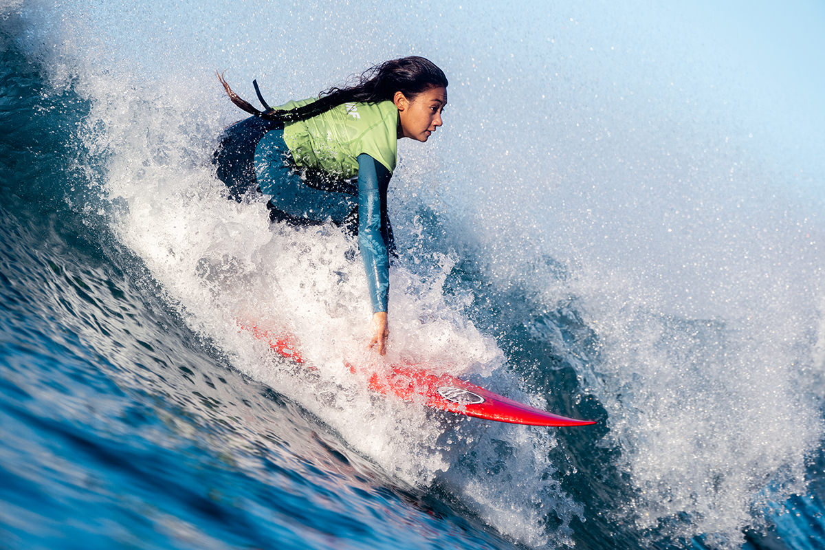 Girl on a surfboard, surfing a wave.