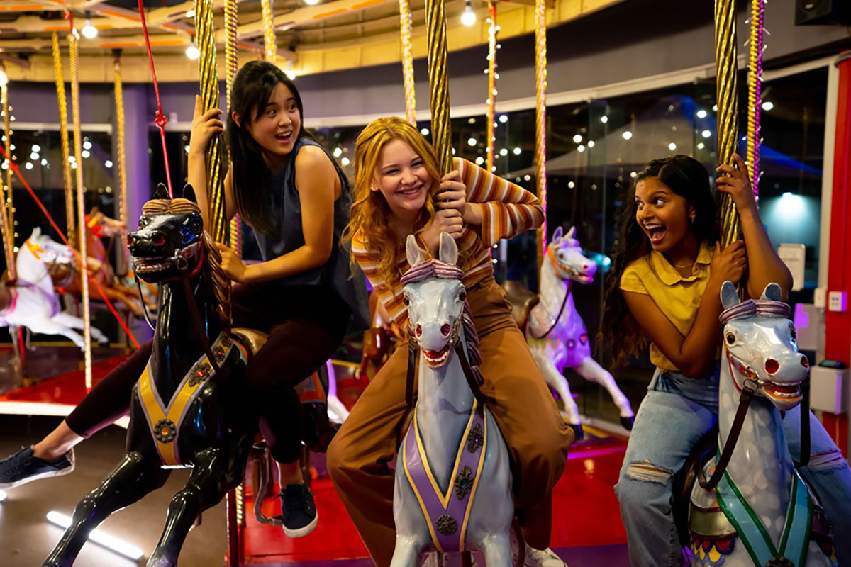 Still from First Day S2, three young girls on a Merry Go Round